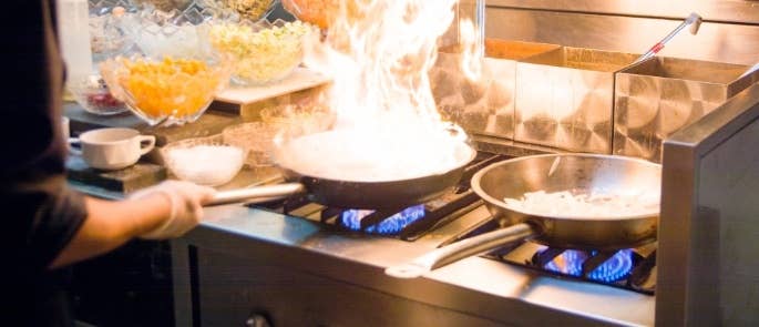 A chef frying food on a stove