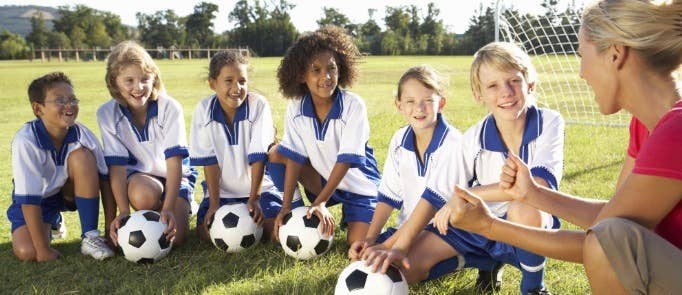 Female coach talks to young football team