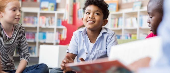 A child listening to the teacher read a story in class