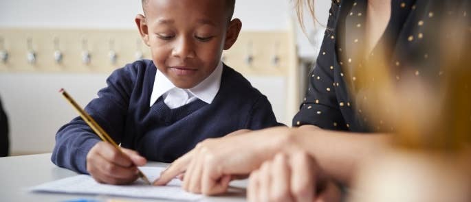 A child and teacher solving a problem together