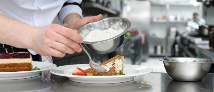 chef plates up dessert in the kitchen