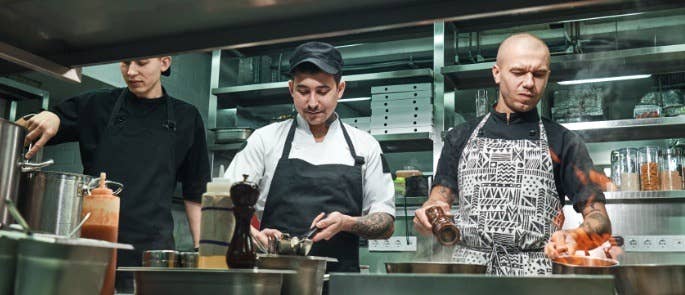 Three chefs working together in the kitchen 