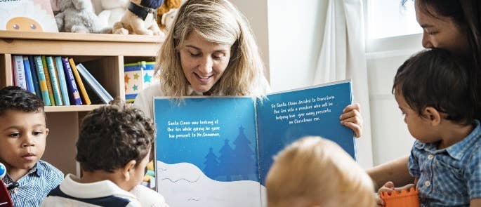 Nursery teacher reading with her students