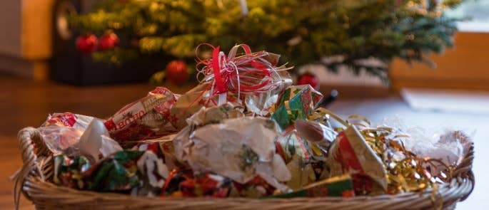 Waste bin full of wrapping paper infront of Christmas tree