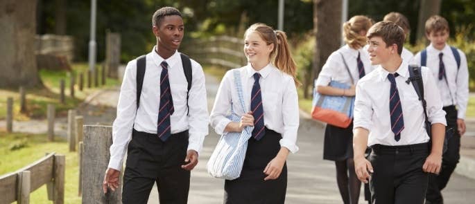 Teenagers in school uniforms walking to class