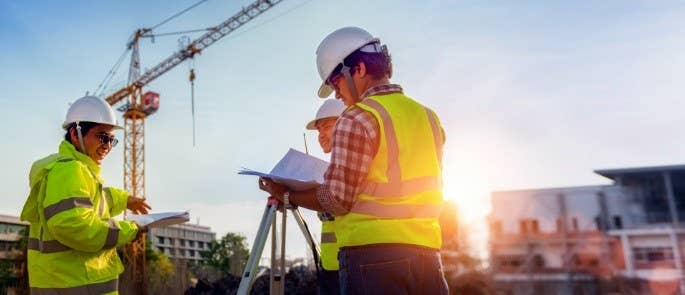 Workers look at documents on construction site