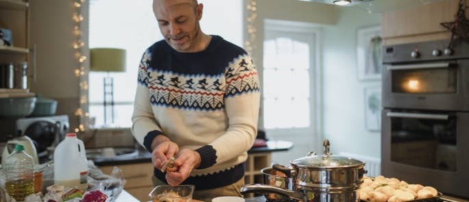 Man peeling vegetables and cooking Christmas dinner