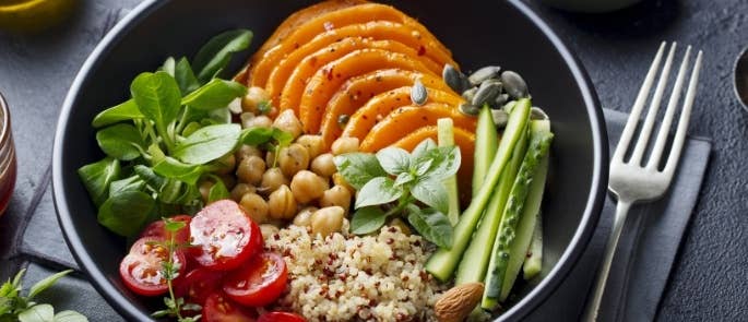 A salad with a variety of vegetables and grains