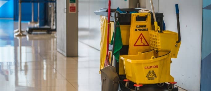 School cleaners trolley with equipment in school corridor