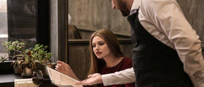 Waiter explaining a restaurant's menu to a customer