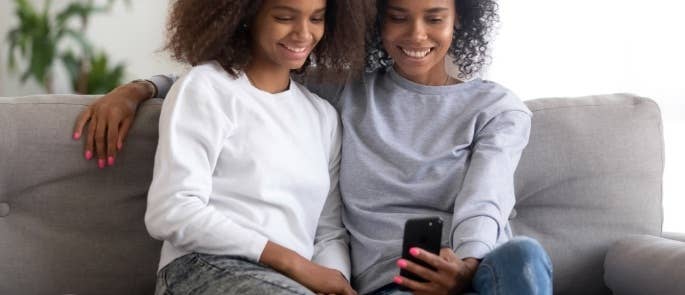 Two girls filming a video on their phone