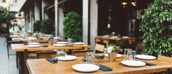 Row of restaurant tables outside set ready for diners