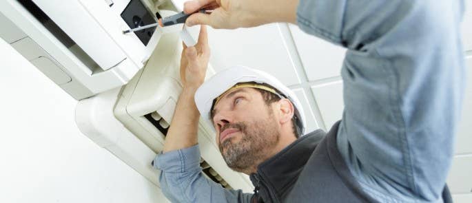 Man-fixing-air-conditioning-unit