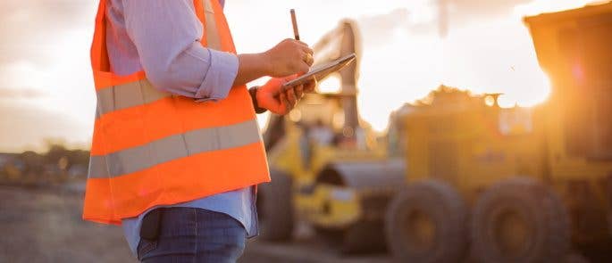 Worker on site writing on clipboard