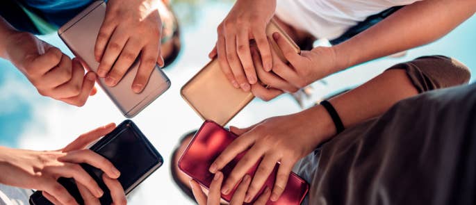 Group of young adults using their smartphones