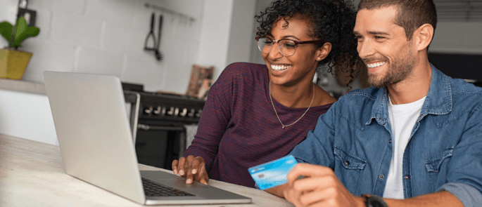 Couple sit in home making an online payment