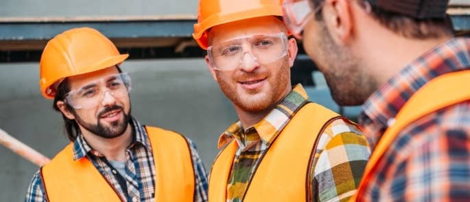 Construction workers wearing orange hard hats