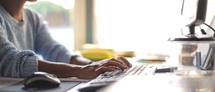 Woman typing at home office desk