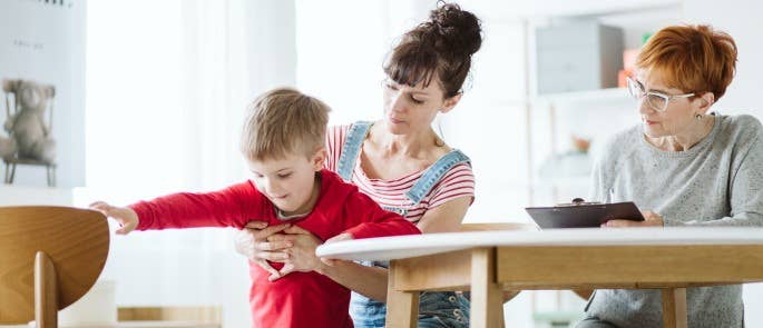 Practitioner taking notes while observing child.