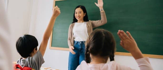 Teacher encouraging pupils to raise hands