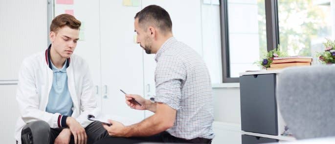 Teacher having supportive conversation with teenage student