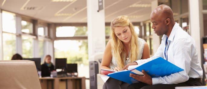 Two teachers discussing policy document