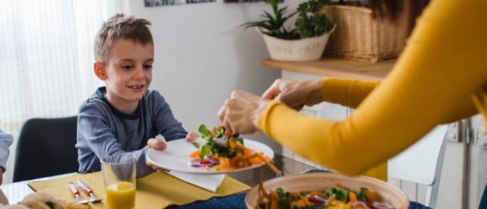 Parent giving plant based food to child