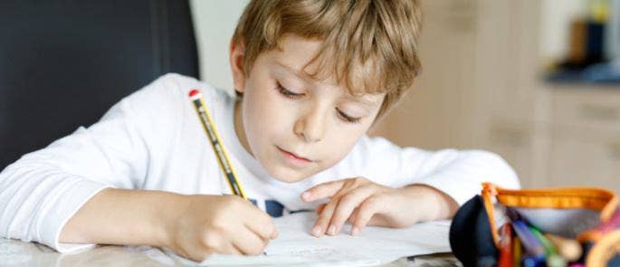 Young boy completing schoolwork at home