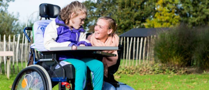 Young girl and carer communicating in the garden