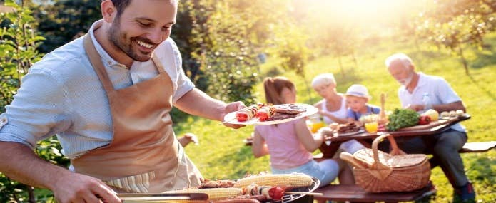 Man serving BBQ to his family