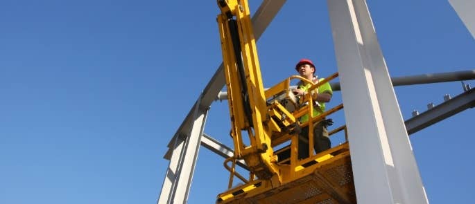 Construction worker using cherry picker