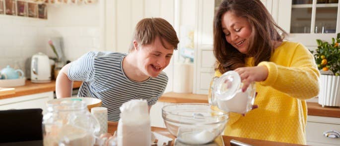 Support worker and service user baking together