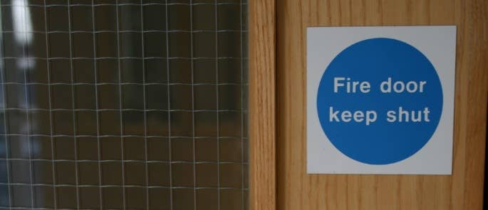 Fire door with fire door keep shut sign and window