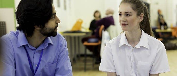 Teacher talking to a pupil in school