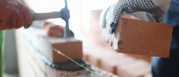 Person laying bricks down