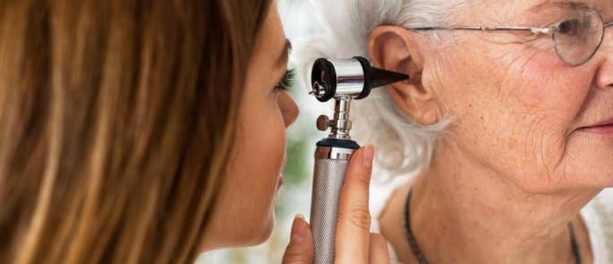 A doctor doing a hearing check on an elderly patient