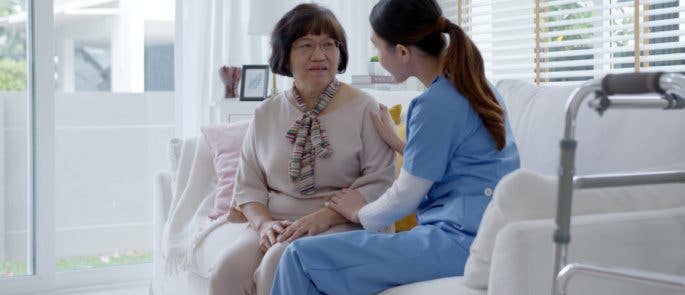 A nurse speaking with an elderly individual