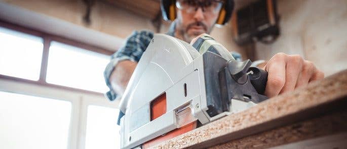 Worker sawing wood