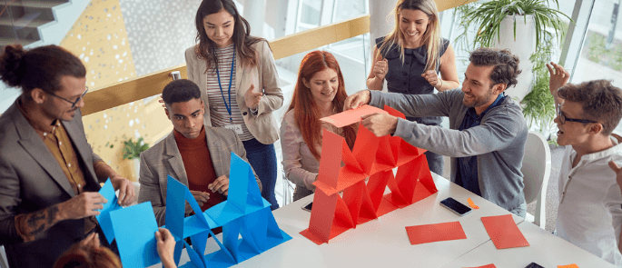 Coworkers doing a card stacking game as a team building exercise