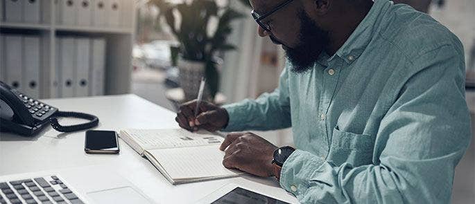 Employee writing his personal development goals in a notepad