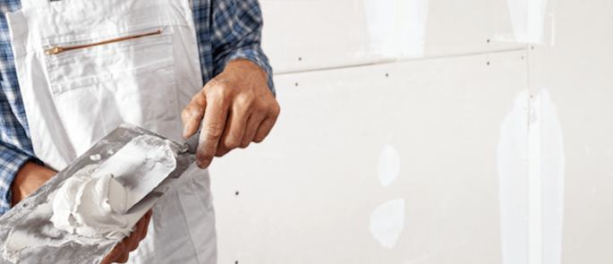 A construction worker using materials containing gypsum.