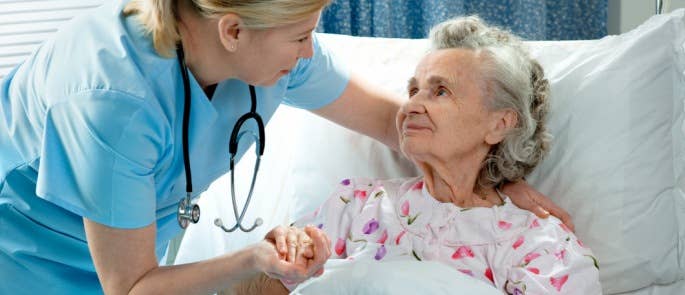 Healthcare professional supporting an elderly person in the hospital