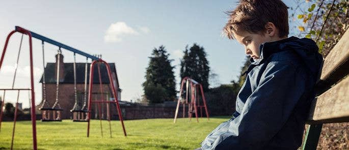 A young child sat on a park bench