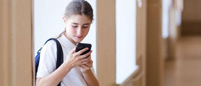 A child at school using her mobile phone