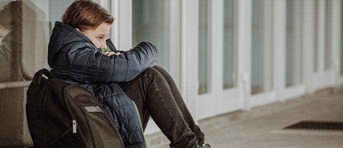 Young boy feeling isolated at school due to peer pressure