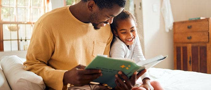 A father helping his child with her reading skills
