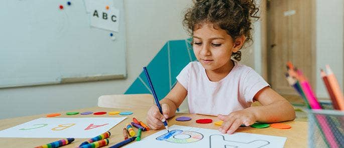 A young girl working on her colouring skills