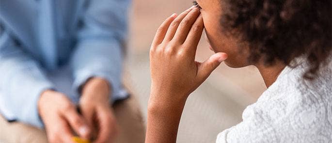 Child talking to teacher at school