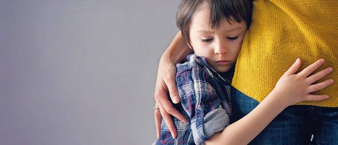 Young boy struggling to leave his parent