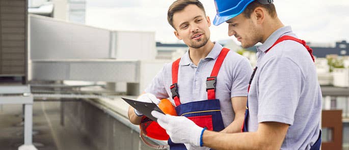 Electrician and apprentice electrician at work